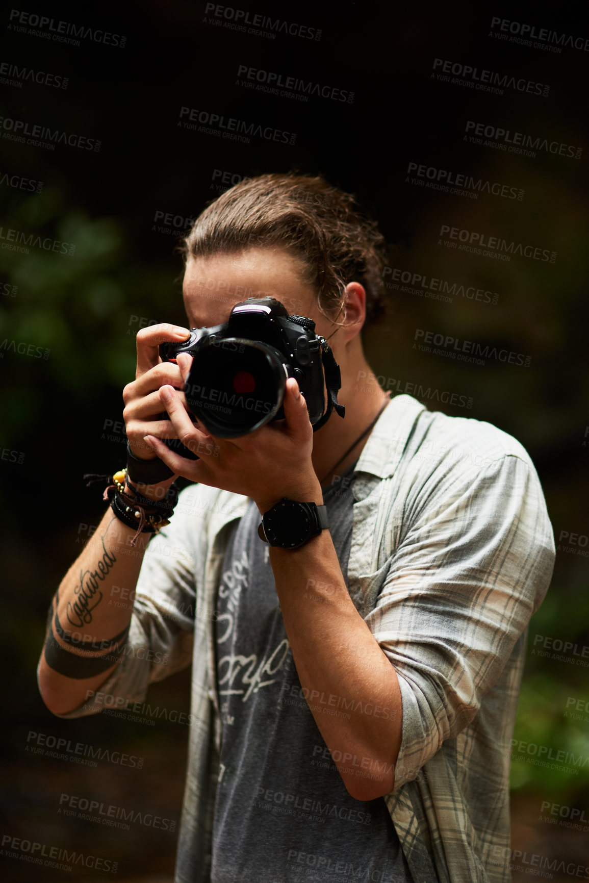 Buy stock photo Shot of a young man holding up his camera and capturing a photo in the viewer's direction