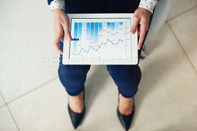 Buy stock photo High angle shot of an unrecognisable businesswoman analysing graphs on a digital tablet in an office