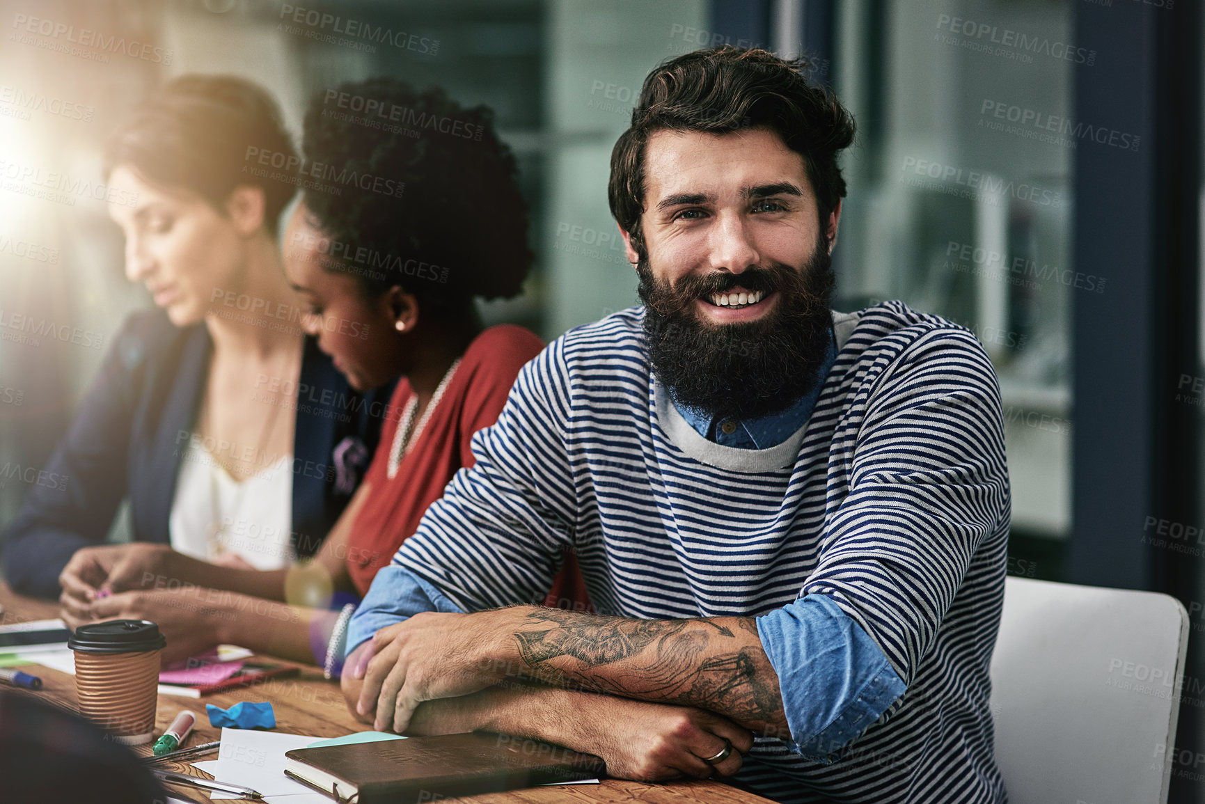 Buy stock photo Portrait of a designer sitting in an office with his colleagues in the background