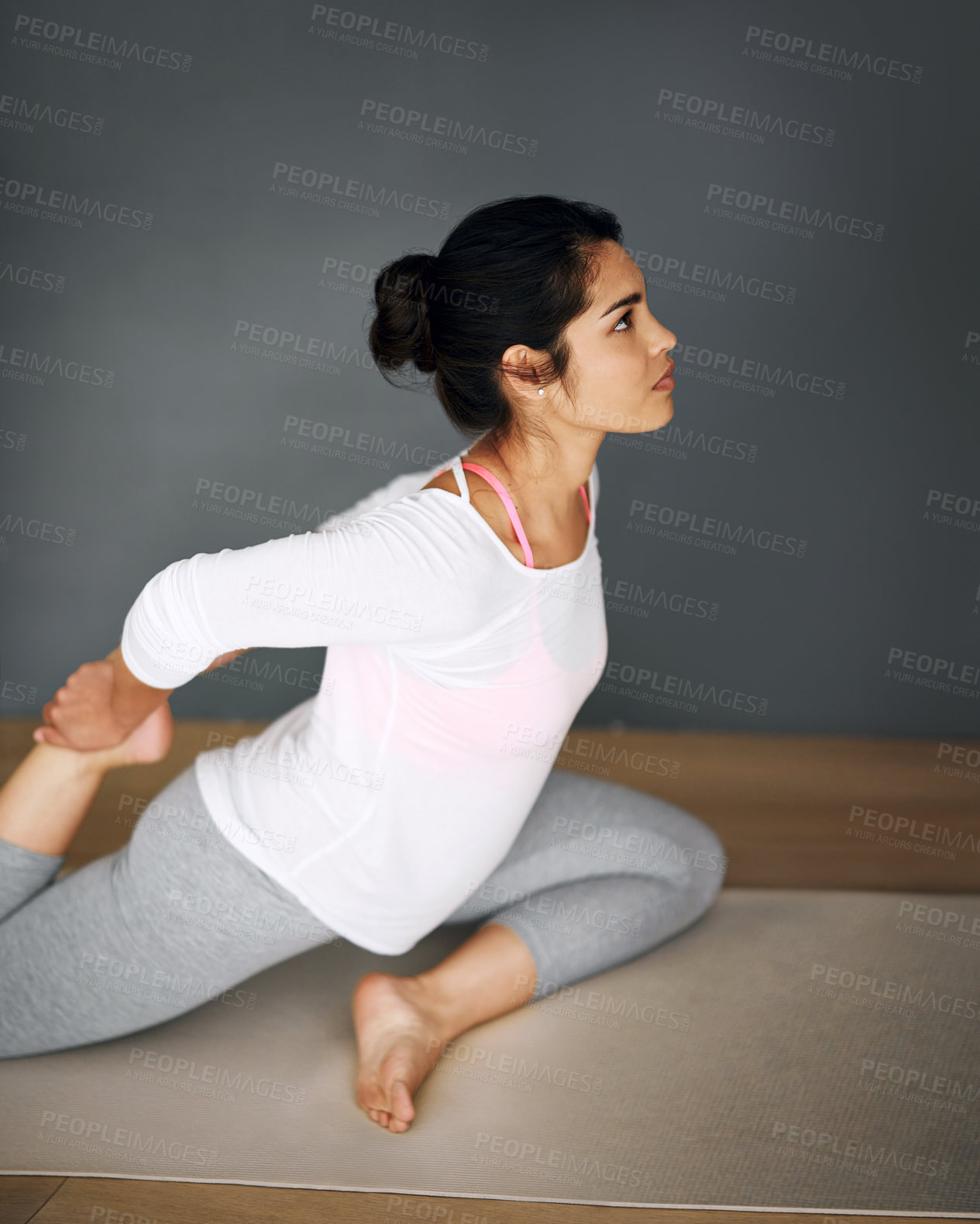 Buy stock photo Shot of a young woman stretching during her yoga routine