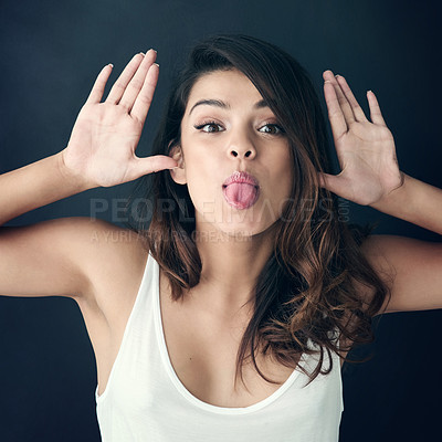 Buy stock photo Cropped shot of a beautiful young woman sticking out tongue against a grey background