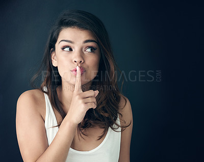 Buy stock photo Woman, secret and thinking with lips on finger for whisper, gossip or silence on a dark studio background. Female person or model in wonder or thought for hush, shush or confidential information