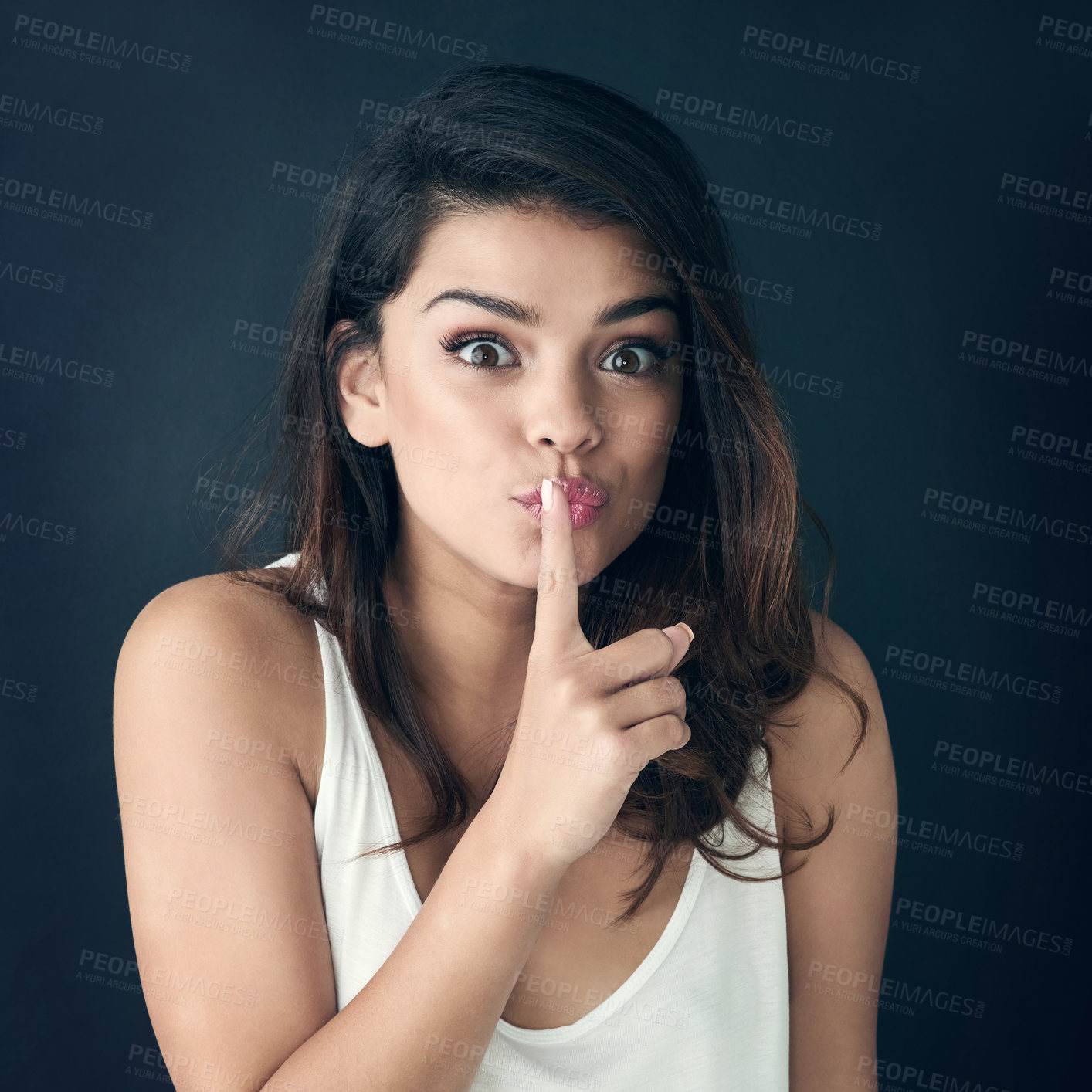 Buy stock photo Woman, portrait and secret with finger on lips for whisper, gossip or silence on a dark studio background. Young female person or model with gesture or emoji for hush, shush or confidential mystery