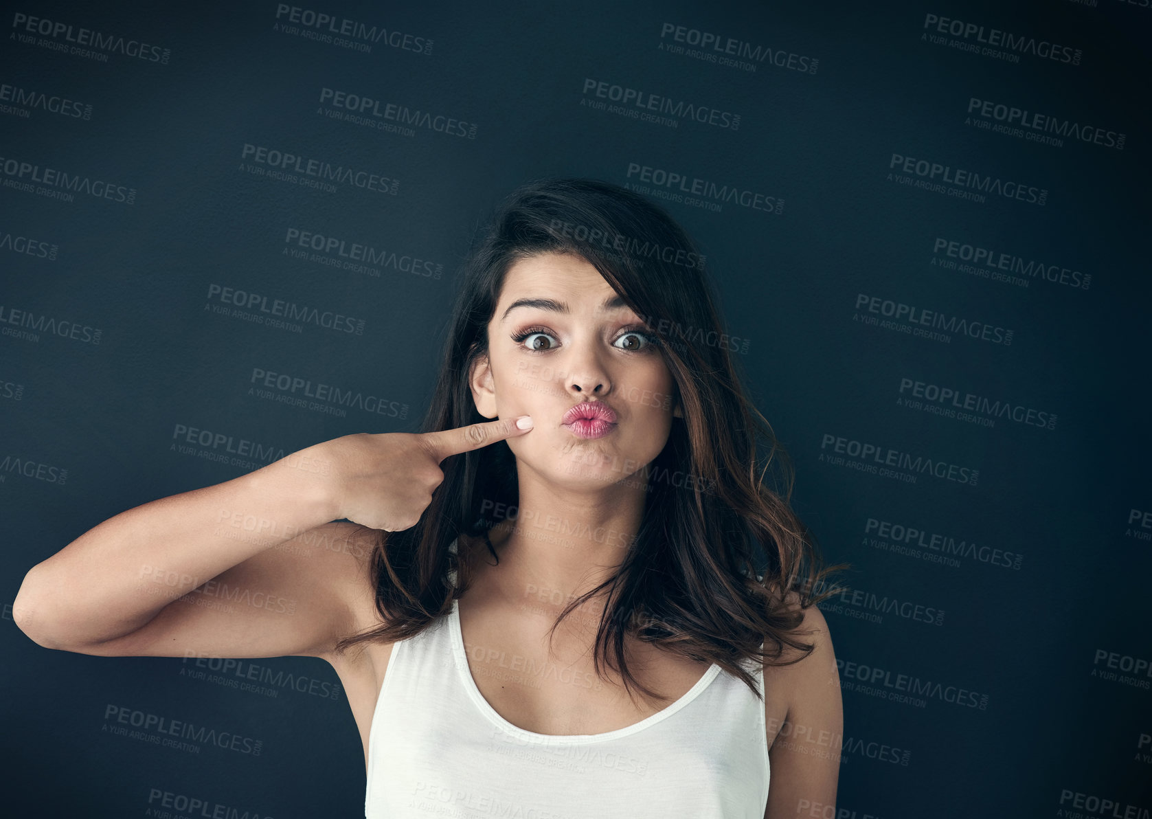 Buy stock photo Portrait, pointing and woman with pout, lipstick and cosmetics on dark studio background. Cheek, funny face and person with confidence, hand gesture and dermatology with beauty, glow and wellness