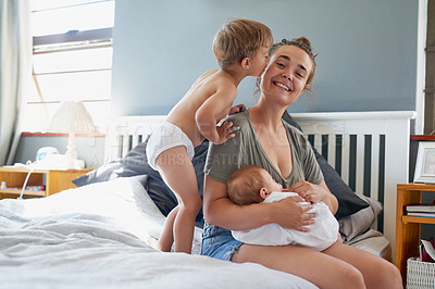 Buy stock photo Shot of a young woman bonding with her two sons at home