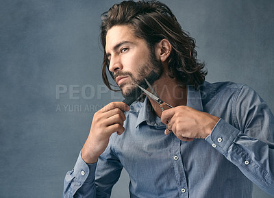 Buy stock photo Scissors, wellness and man trimming beard on face for beauty routine, grooming and cosmetic hygiene on grey studio background. Barber, skincare and model cutting facial hair for clean style with comb