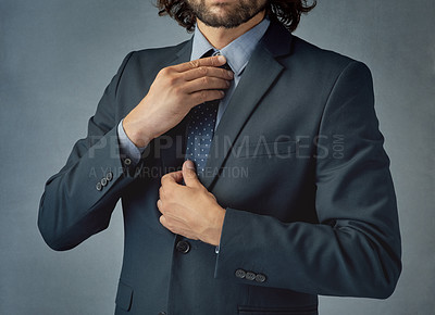 Buy stock photo Cropped shot of a stylishly dressed young man adjusting his tie