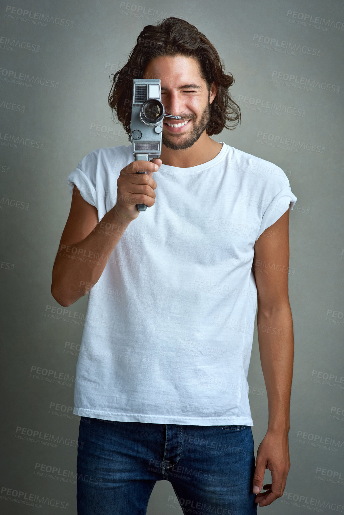 Buy stock photo Studio portrait of a young man posing with a vintage camera against a grey background