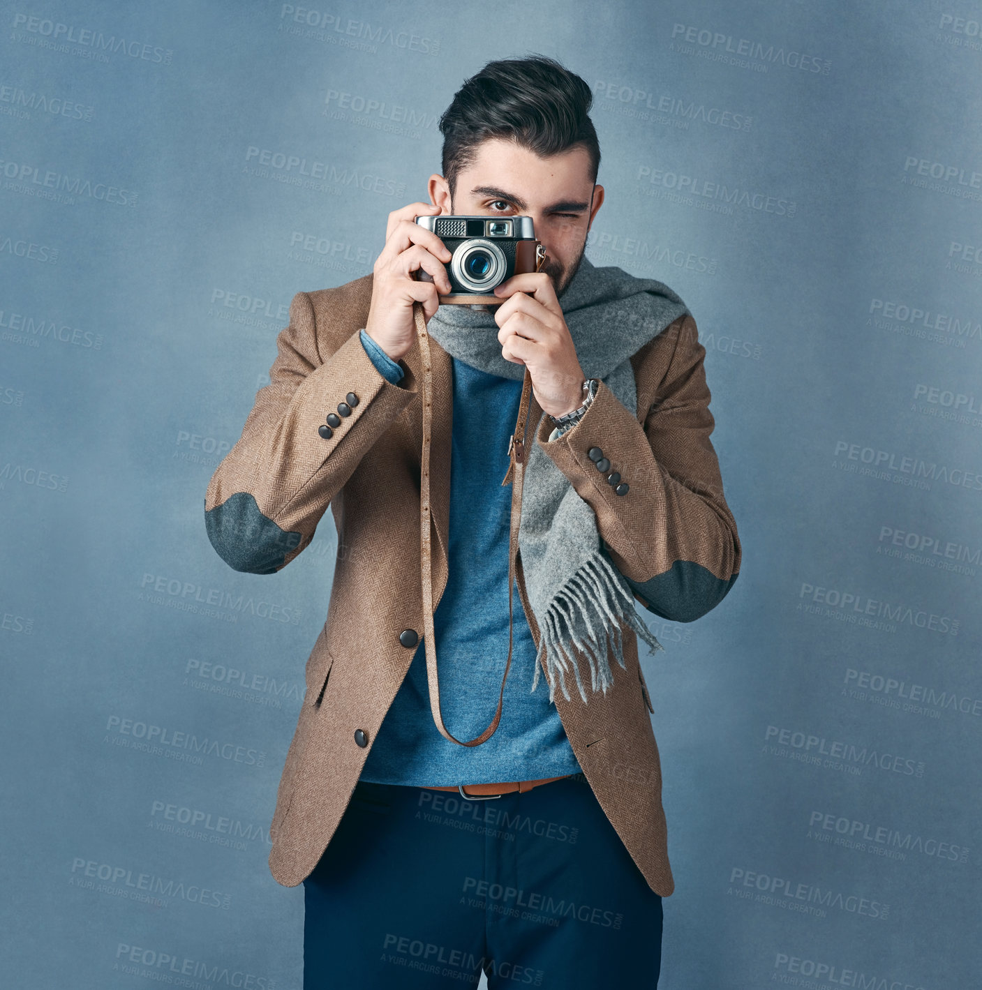 Buy stock photo Studio portrait of a stylishly dressed handsome young man holding a vintage camera