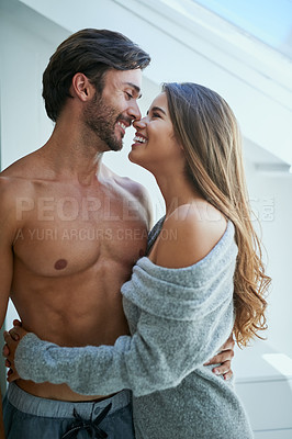 Buy stock photo Shot of an affectionate young couple kissing at home