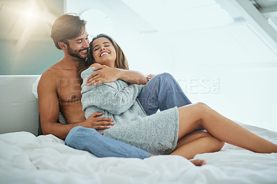 Buy stock photo Shot of an affectionate young couple sharing an intimate moment in bed