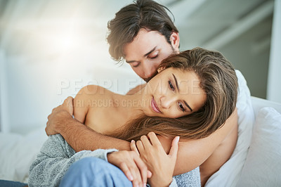 Buy stock photo Shot of an affectionate young couple sharing an intimate moment in bed