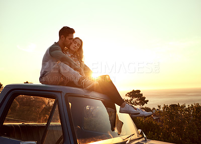 Buy stock photo Shot of an affectionate young couple enjoying a roadtrip together