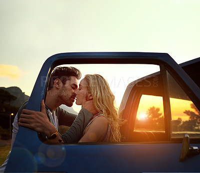 Buy stock photo Shot of an affectionate young couple enjoying a roadtrip together