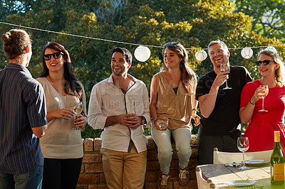 Buy stock photo Shot of a group of happy young friends hanging out at a backyard dinner party