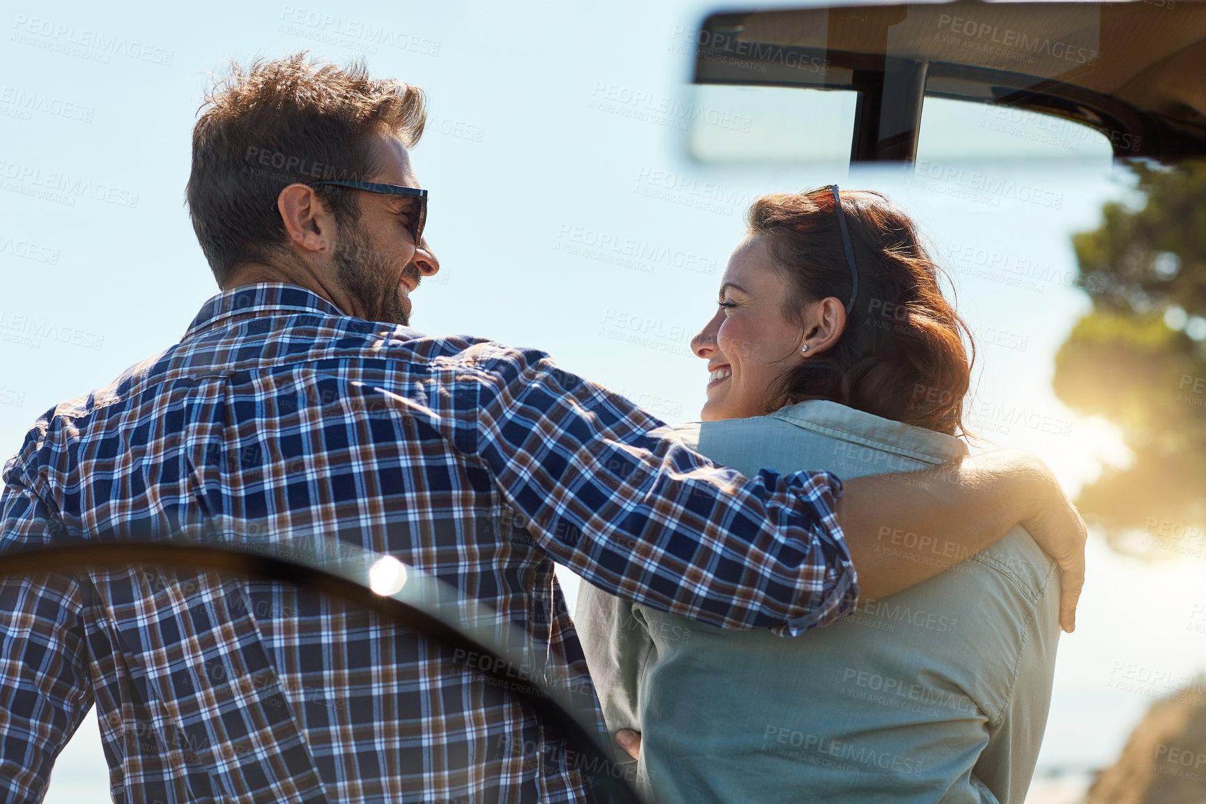 Buy stock photo Rearview shot of an affectionate couple taking in the sights while enjoying a road trip