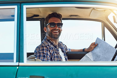 Buy stock photo Cropped shot of a handsome man checking a map while enjoying a roadtrip