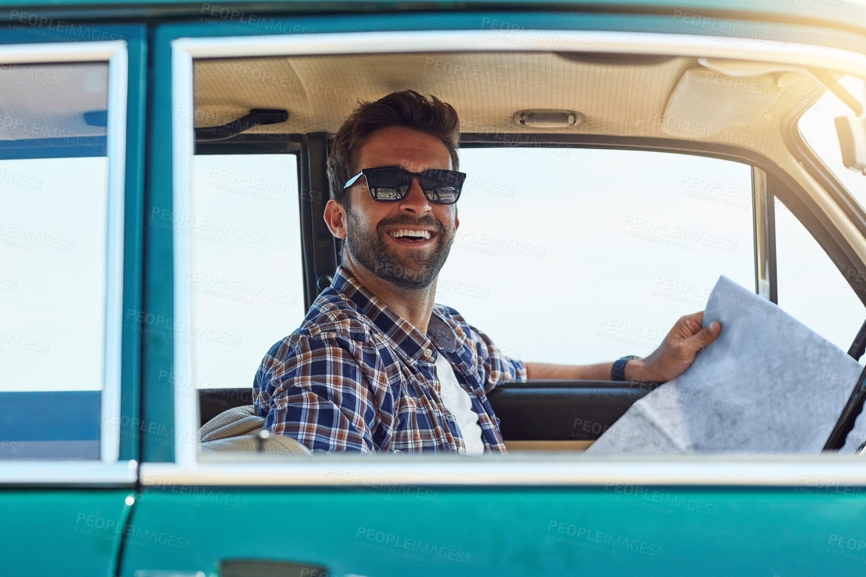 Buy stock photo Cropped shot of a handsome man checking a map while enjoying a roadtrip