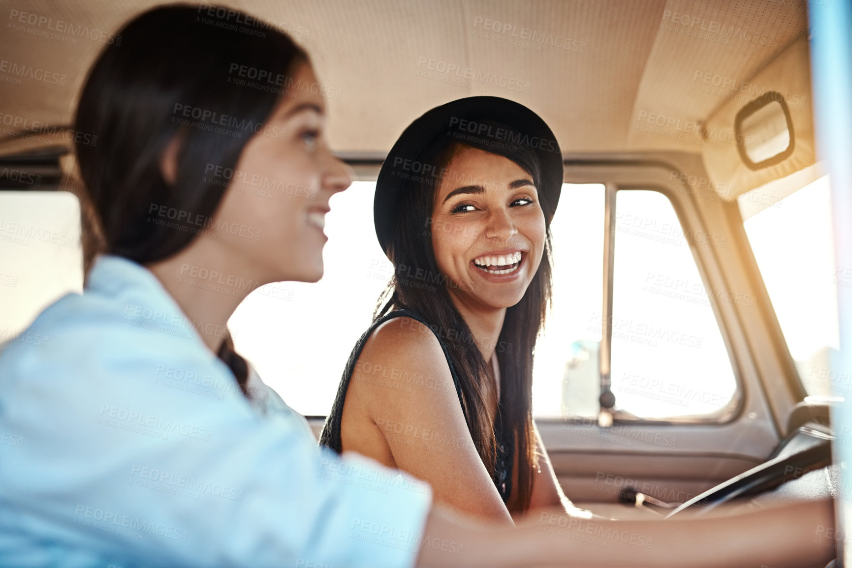 Buy stock photo Shot of two happy young friends going on a road trip