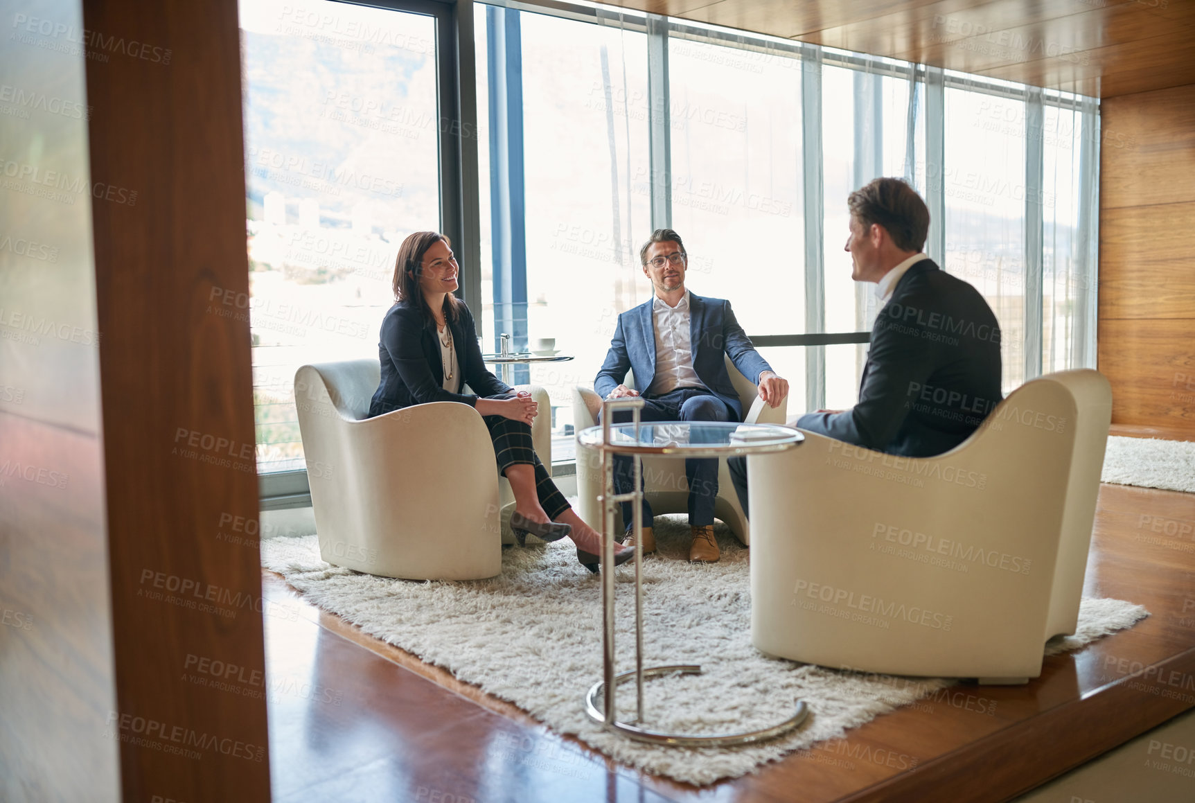 Buy stock photo Shot of a group of business people having a discussion in a modern office