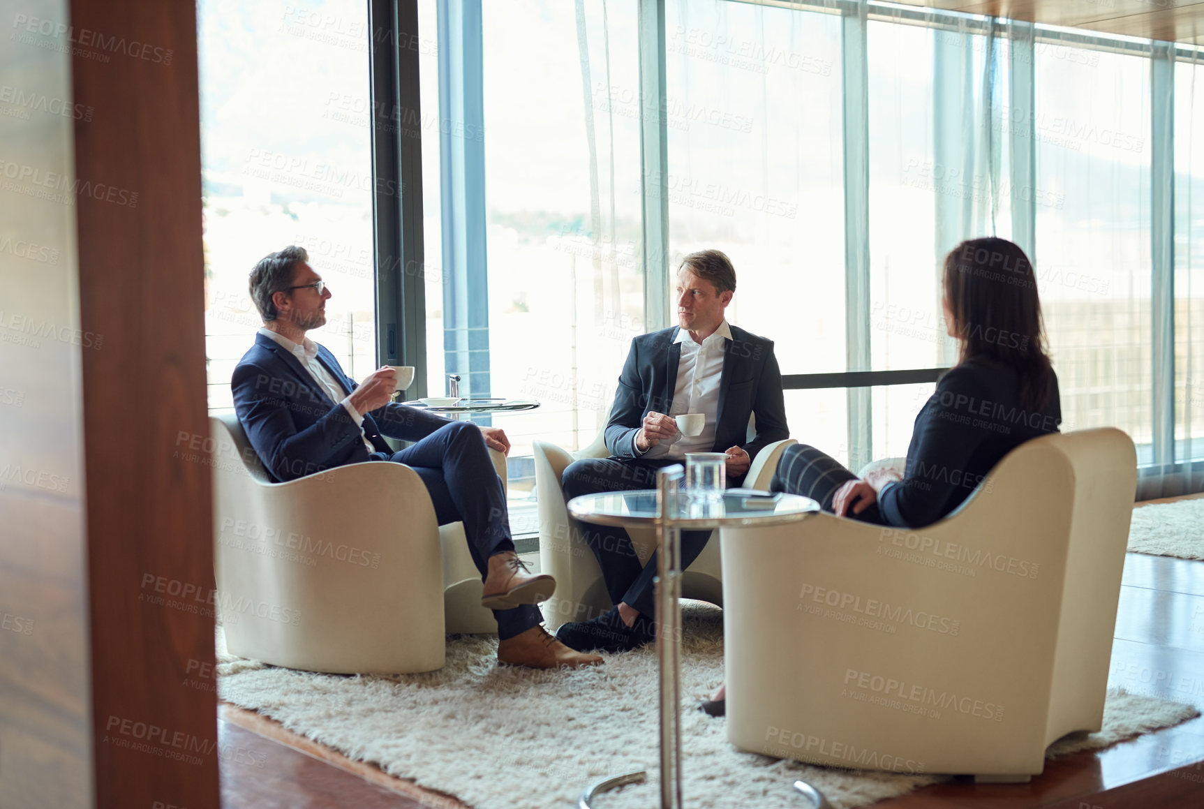 Buy stock photo Shot of a group of business people having a discussion in a modern office