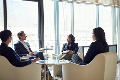 Buy stock photo Shot of a group of business people having a discussion in a modern office