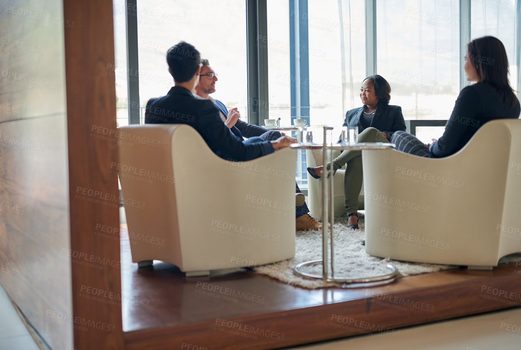 Buy stock photo Shot of a group of business people having a discussion in a modern office