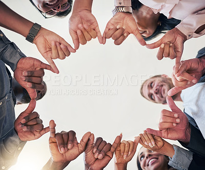 Buy stock photo Low angle shot of a team of creative colleagues making a circle with their hands in the office