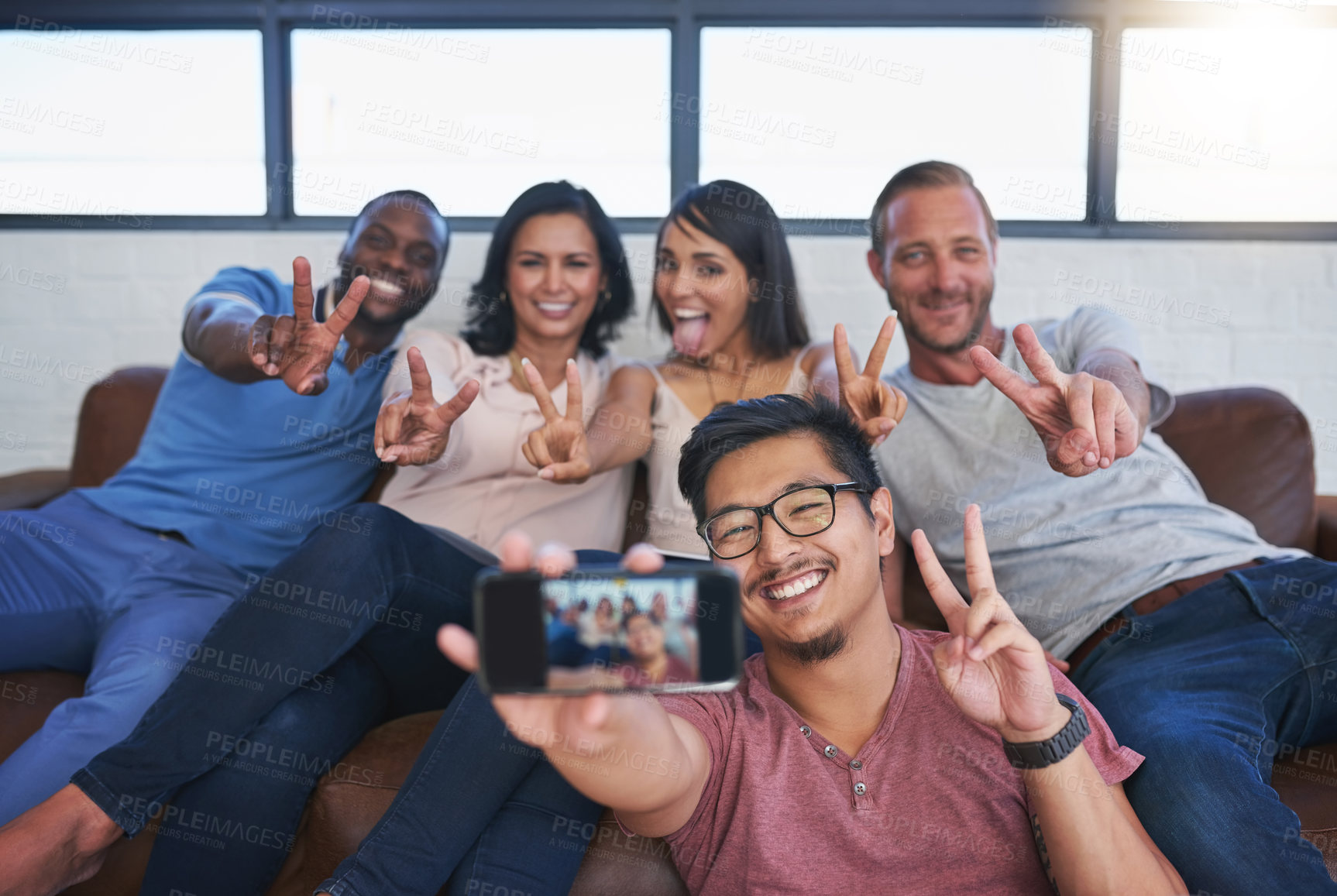 Buy stock photo Shot of a happy group of creative colleagues posing for a selfie together in the office