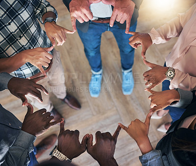 Buy stock photo High angle shot of a team of unidentifiable colleagues making a circle with their hands in the office