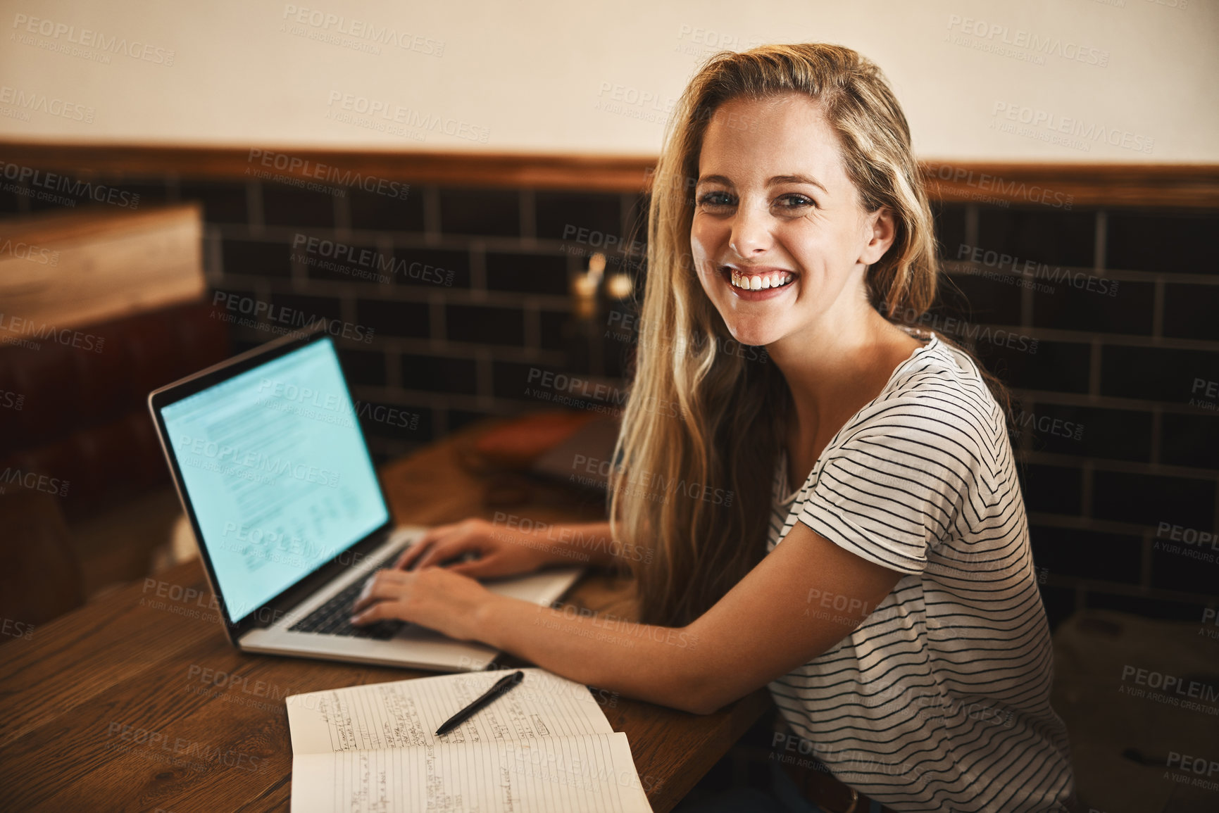 Buy stock photo Portrait of a happy young student using her laptop to study at a cafe table