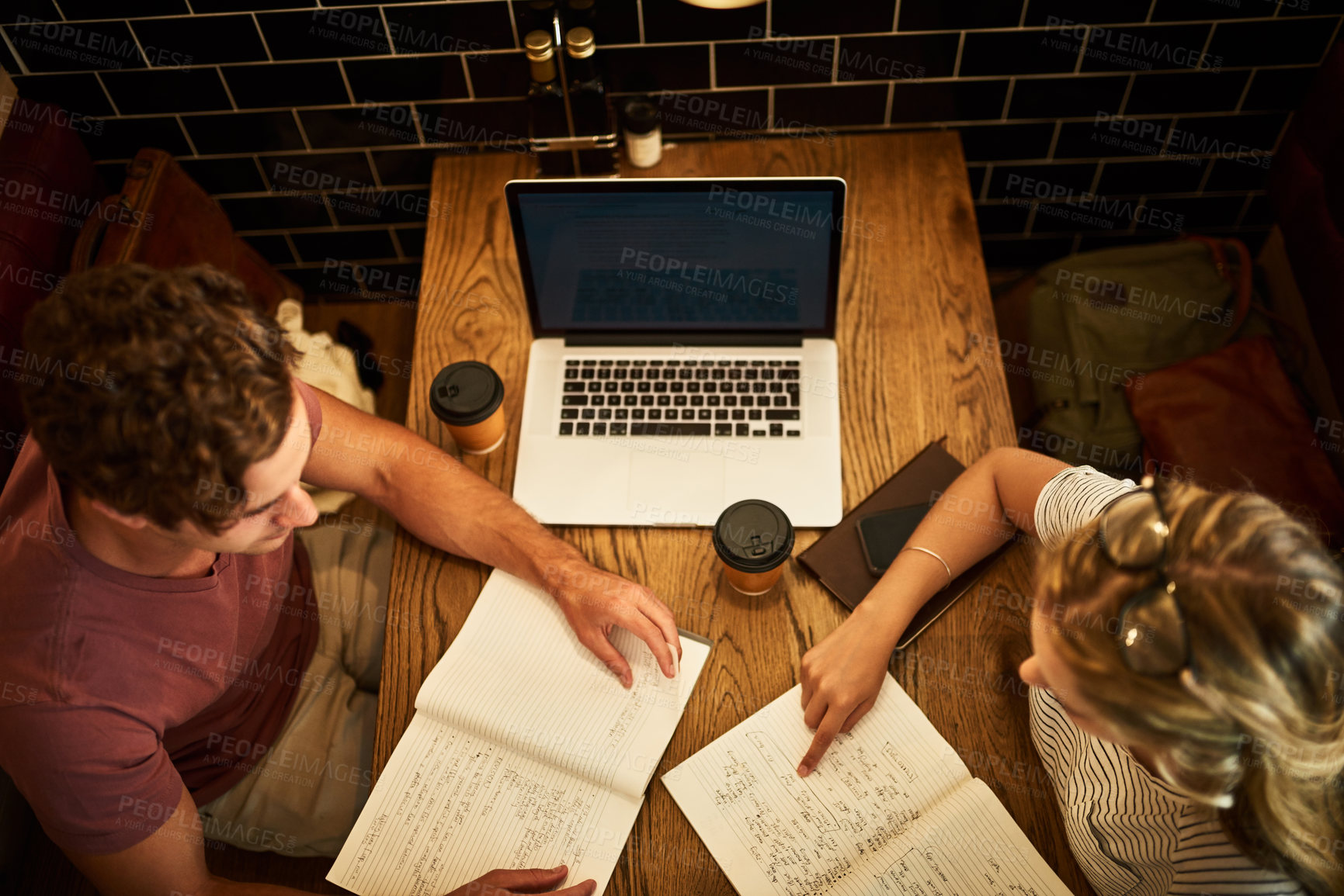 Buy stock photo Students, together and study notes in coffee shop for test review, examination and academic homework for university. Man, girl and top view with notebook for revision session, knowledge and education