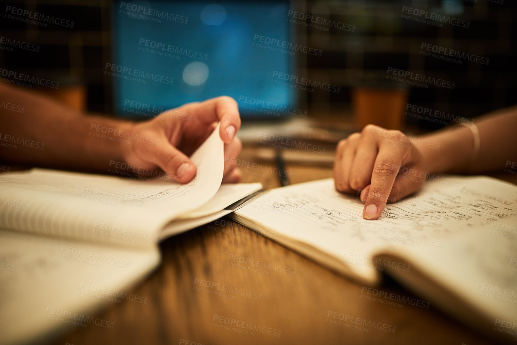 Buy stock photo Cropped shot of two unidentifiable students having a study session at a cafe table