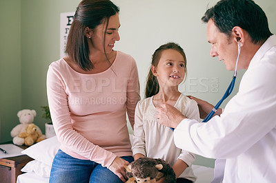 Buy stock photo Shot of a male doctor checking his young patient's heart rate
