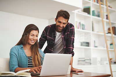Buy stock photo Shot of a happy young man checking in on his wife while she works from her desk at home