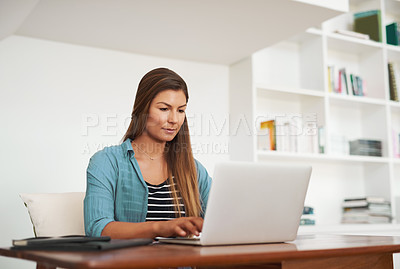 Buy stock photo Shot of a focussed freelancer using her laptop while working from her office at home