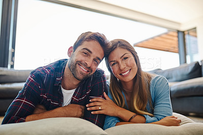 Buy stock photo Portrait of a happy young couple relaxing together on their living room floor
