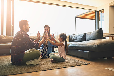 Buy stock photo Shot of a happy family of three playing a clapping game together at home