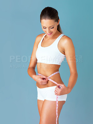 Buy stock photo Woman, measuring tape and health, diet with waist size from weight loss isolated on blue background. Healthy, tummy tuck and body measurement with female person in studio with wellness and fitness