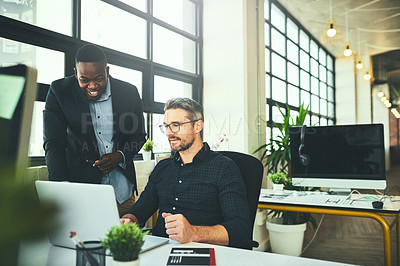 Buy stock photo Cropped shot of two businessmen working on a laptop in their office