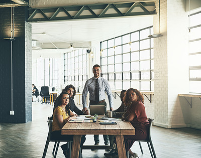 Buy stock photo Portrait of a team of smiling businesspeople gathered around a table in their office during a meeting