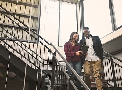 Buy stock photo Business people, tablet and talking on stairs in workplace with discussion for project management or client briefing. Professional, employees or walking with technology for teamwork on creative ideas