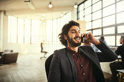 Buy stock photo Cropped shot of a handsome young businessman talking on his cellphone in the office