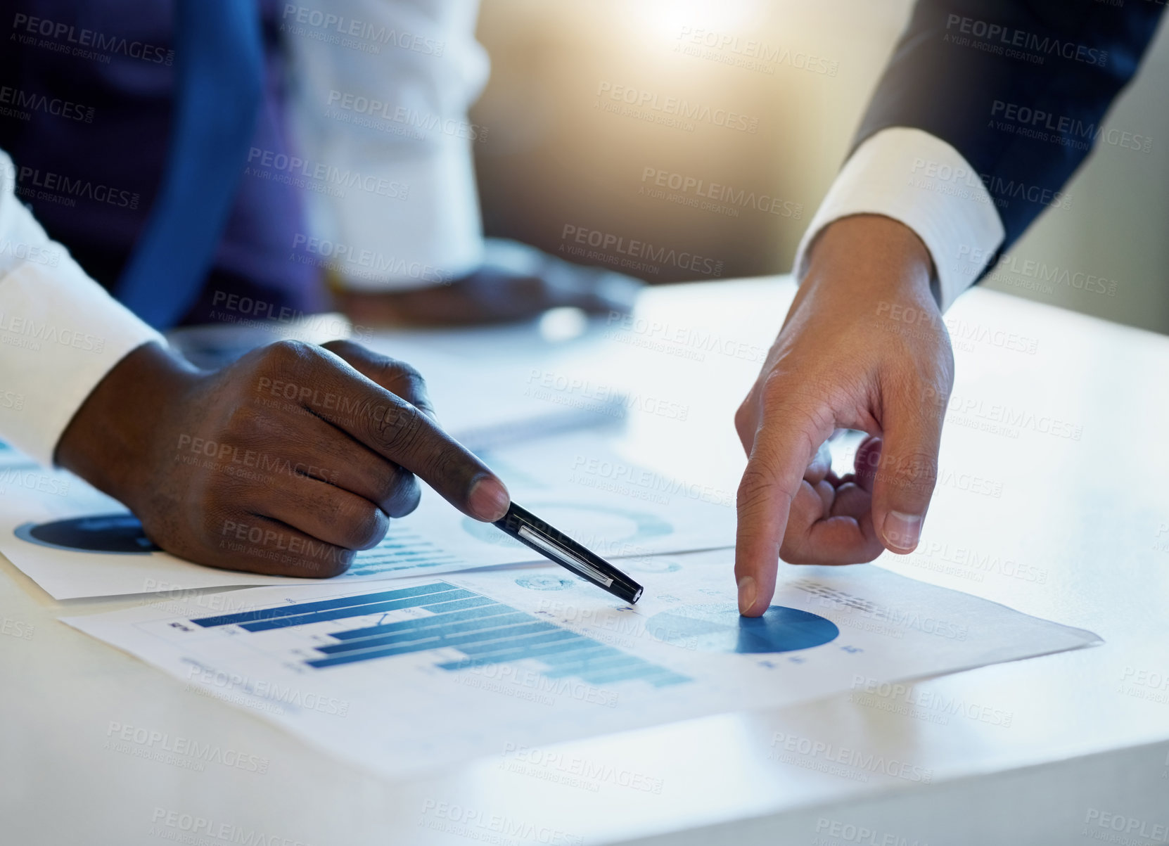 Buy stock photo Shot of two unrecognisable businessmen going through paperwork in an office