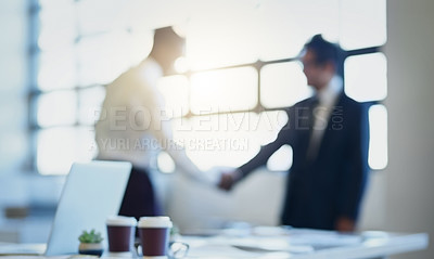 Buy stock photo Blurred shot of two businessmen shaking hands in an office