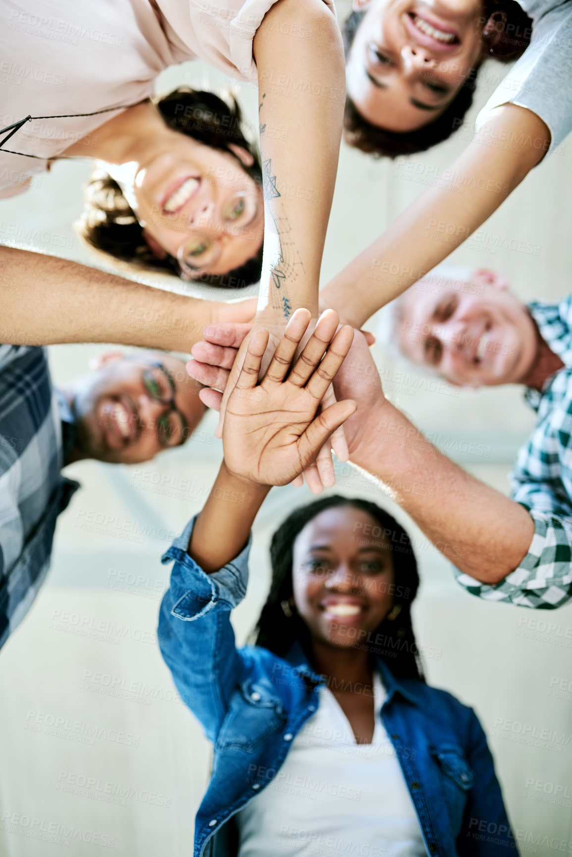 Buy stock photo Shot of a group of creatives stacking their hands in unity