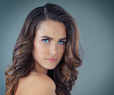 Buy stock photo Cropped portrait of a beautiful young woman posing against a grey background in the studio