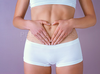 Buy stock photo Person, heart hands and stomach in studio for wellness, results and underwear by purple background. Model, abdomen and gut health with icon for love, symbol and emoji for self care with digestion