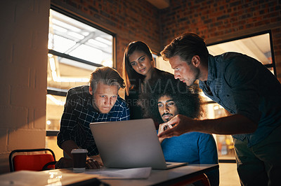 Buy stock photo Shot of a group of designers working together on a laptop