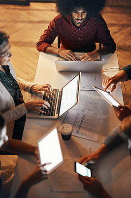 Buy stock photo High angle shot of a group of designers using modern technology in a meeting
